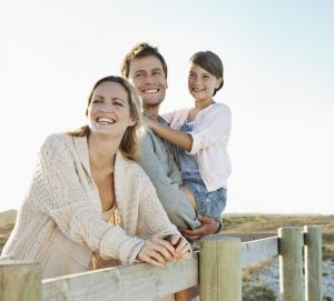 Smiling family with daughter (10-12) on beach