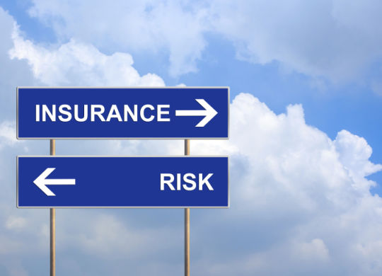 Insurance and risk on blue road sign
